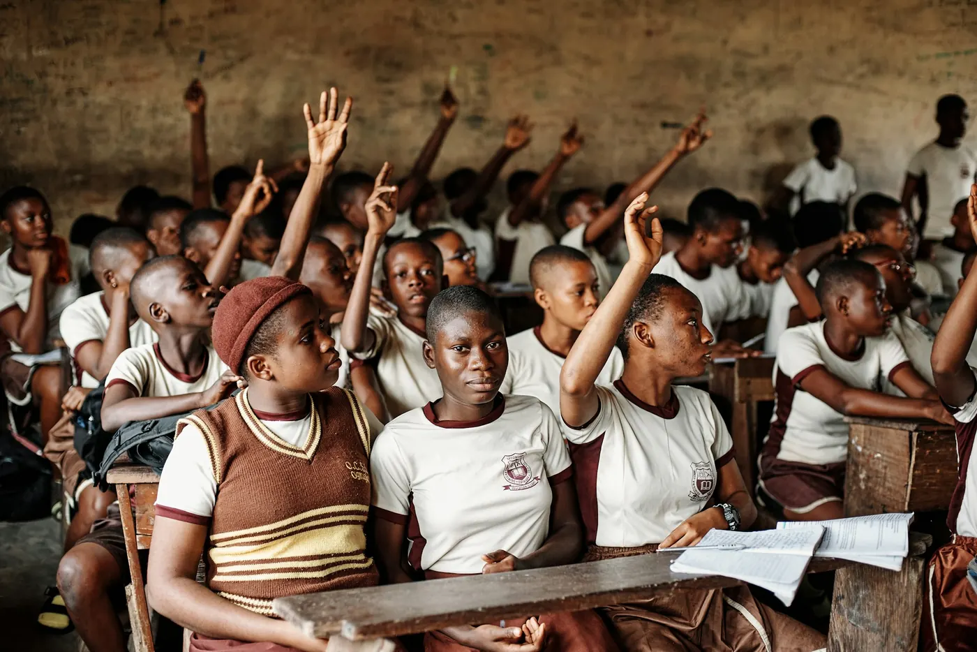 Schoolchildren learning on wooden benches in a Nigerian classroom